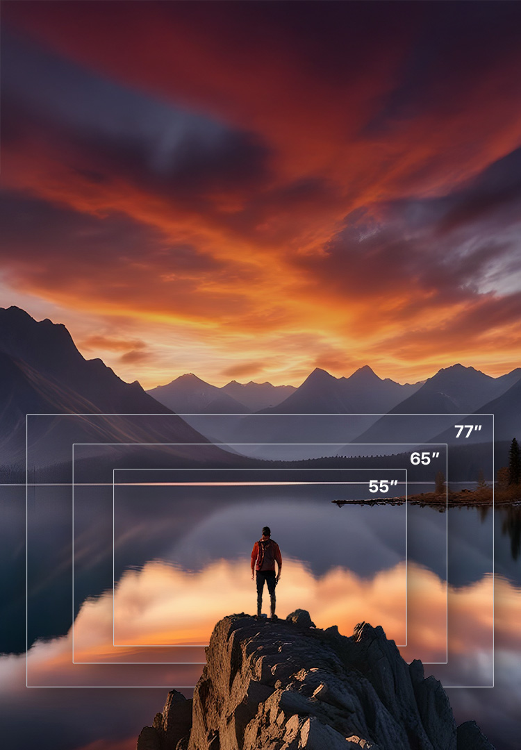 A man standing on a rock above a lake and mountains as the sun sets.