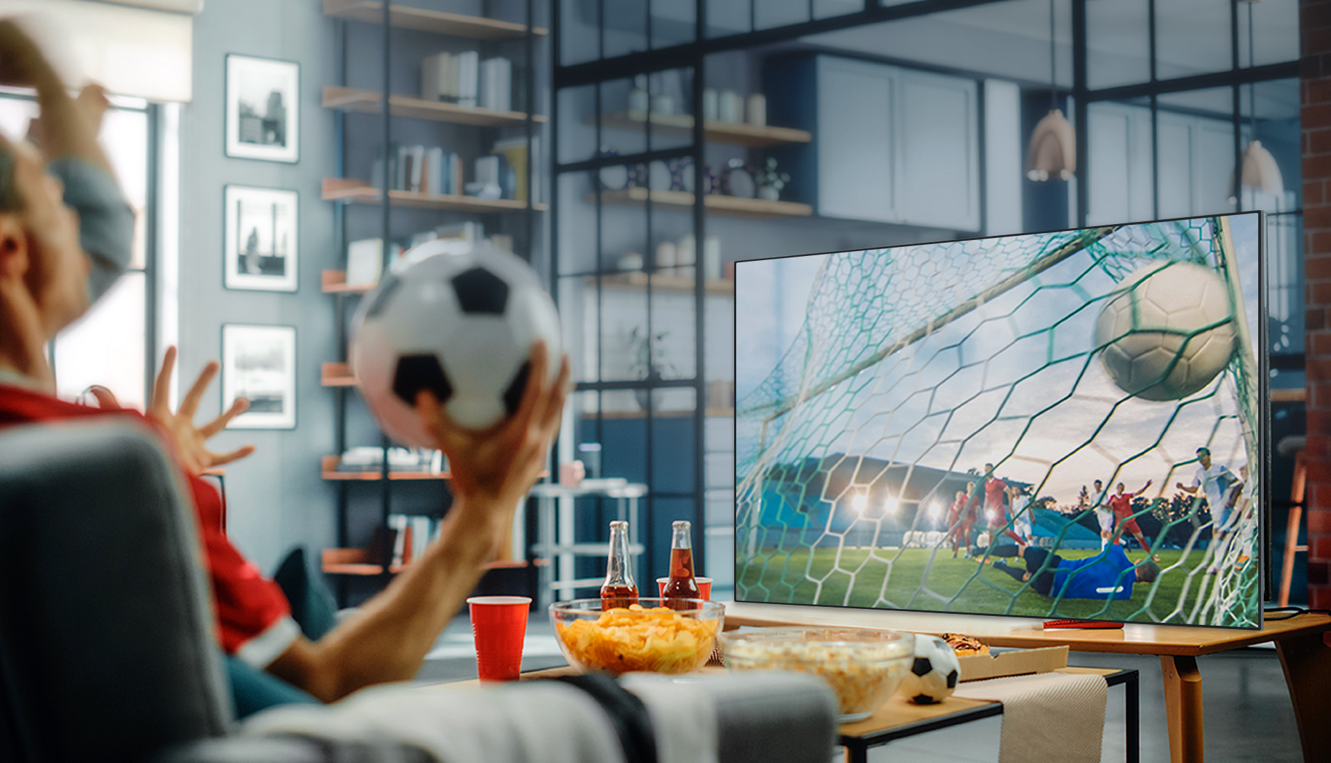 An image of several people holding a soccer ball and watching a soccer match.